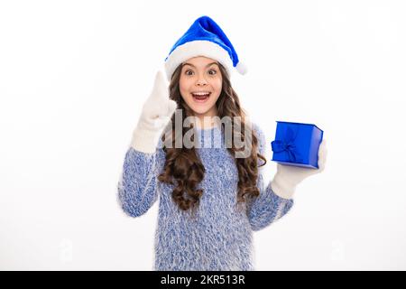 Christmas and New Year concept. Smiling teen kid girl in pink dress holding a big present gifts box on background with copy space. Stock Photo