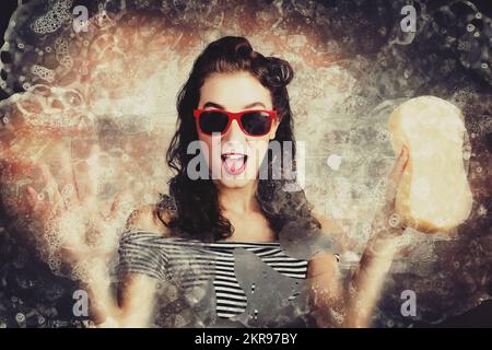 Pin up style photo of cute and funny girl doing a window rinse and clean with sponge at car wash. Bygone services Stock Photo