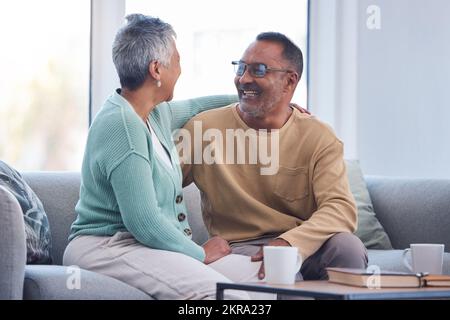 Elderly couple, smile and hug laughing on sofa or relaxing and bonding time together at home. Happy man and woman relax and enjoying social Stock Photo