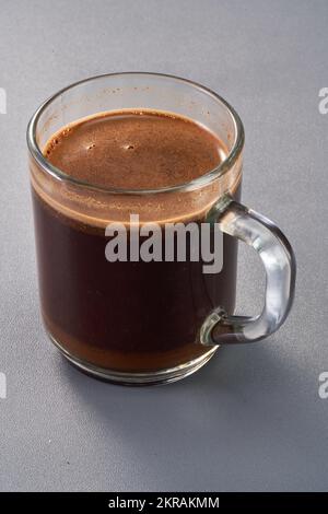 a glass of brewed coffee in a transparent cup with crema on top Stock Photo