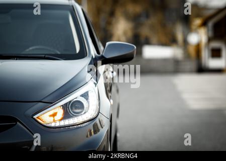 Front optics and side rear view mirror of a gray car Hyundai Accent with copy space. Stock Photo