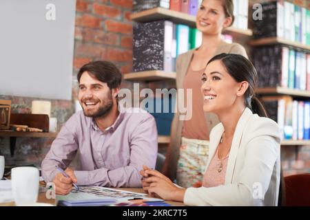 Getting the job done, time and again. three business associates working together on a project. Stock Photo