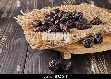 Dried mission figs on burlap and wooden background. Stock Photo