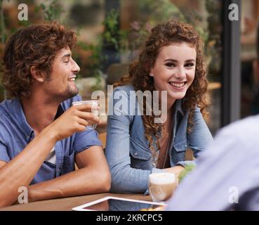 We cant continue this level of coolness on an empty stomach. Young people enjoying a beverage at a sidewalk cafe. Stock Photo