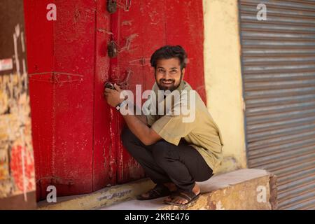 Portrait of a happy young man unlocking door Stock Photo