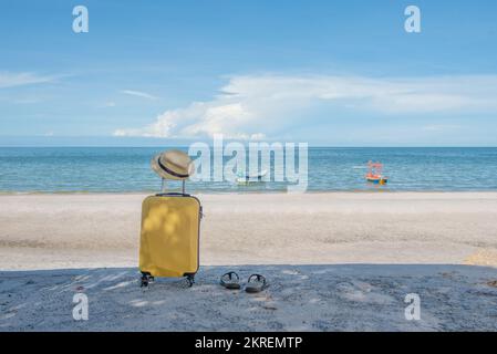 Traveling suitcase with hat on the beach, traveling and relaxing time concept. Stock Photo