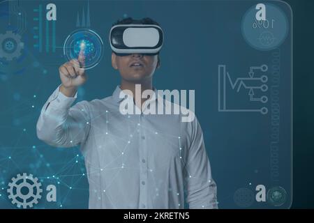 Man wearing VR headset and pointing at digital Screen Stock Photo