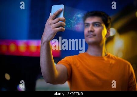 Young man using face recognition software via smartphone Stock Photo