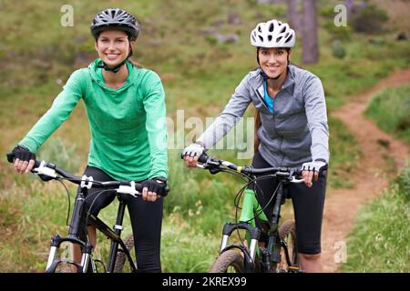 Cycling sisters. Two young cyclists enjoying their ride along a trail. Stock Photo