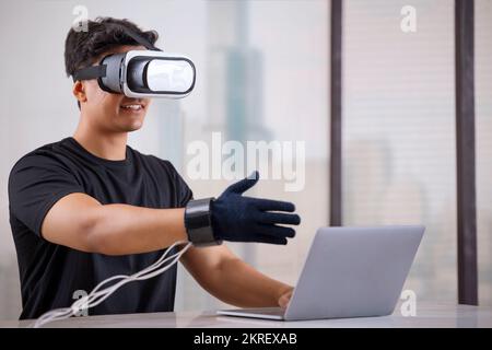 Man wearing VR headset and haptic glove interacting with virtual object/person in the metaverse Stock Photo