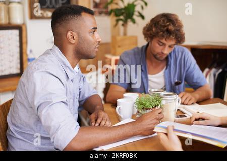 We still have so much work to cover - study group. Friends hanging out and studying together in a coffee shop. Stock Photo