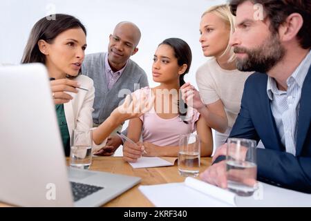 Brainstorming about their latest project. a group of business people in the middle of a discussion. Stock Photo