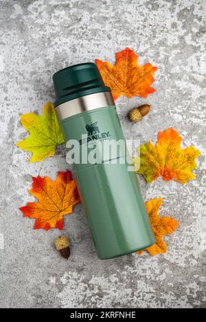 Antalya, Turkey - November 28, 2022: Stanley Action Trigger thermos mug with leaves in autumn colors on stone background Stock Photo