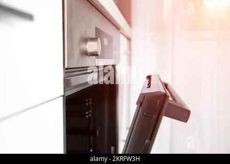 Modern electric oven with hinged door, clock and cooking timer function. Stock Photo
