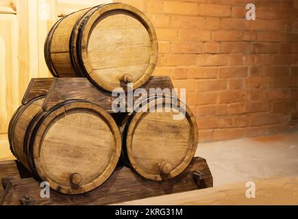 Three wooden barrels of gunpowder against a brick wall. Old antique barrels. Copy space for text, historical Stock Photo