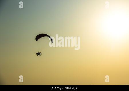 motor gliding in during sunset background with silhouette in a desert of the Rann of Kutch in Gujarat ,India. Stock Photo