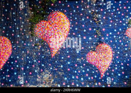 Painted wall on a public street with joyfull heart shapes and various colors Stock Photo