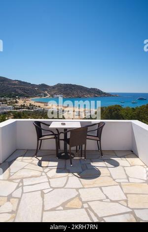 Amazing view from a balcony with chairs and a table overlooking the famous Mylopotas beach in Ios Greece Stock Photo