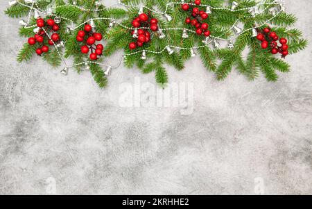 Christmas tree branches red berries silver garland decoration Stock Photo