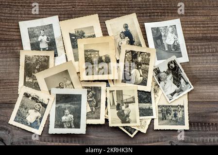 Vintage family photos wooden table background. Old pictures used paper Stock Photo