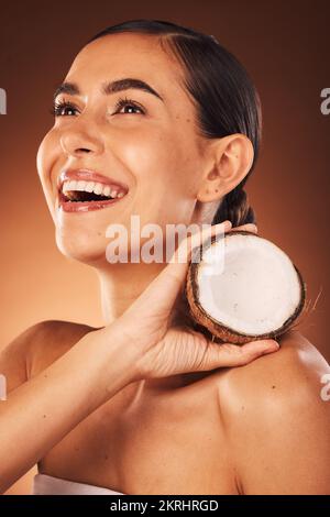 Skincare, coconut and woman in studio happy to promote fruit diet benefits, beauty cosmetics or facial treatment. Smile, young or healthy woman Stock Photo