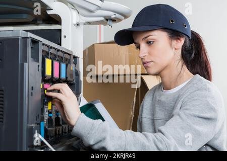 young female technician fixing a printer Stock Photo