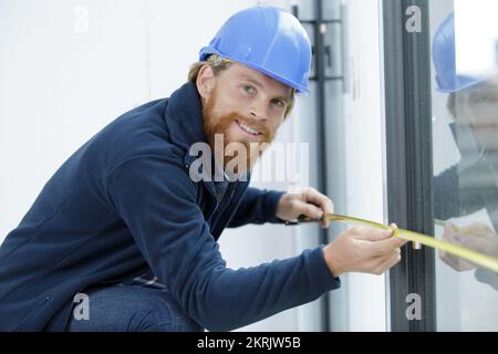 worker using tape measure the window in construction site Stock Photo