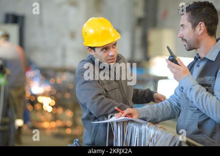 two builders in helmets working with walkie talkie Stock Photo
