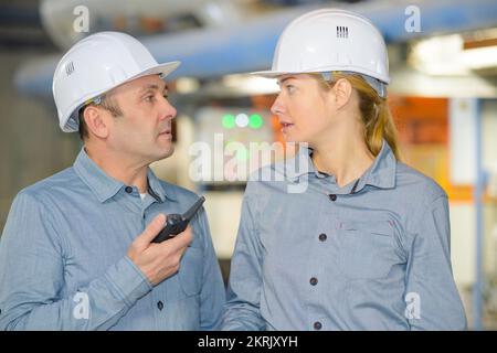 woman with engineer using a walkie talkie Stock Photo