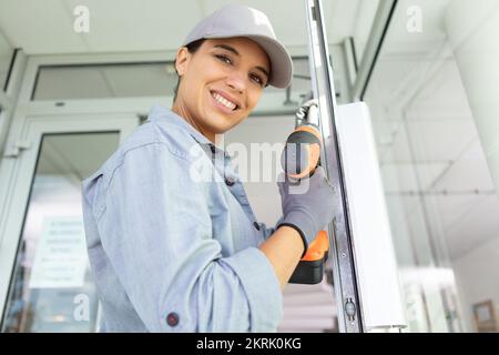 female carpenter using electric drill in workshop Stock Photo