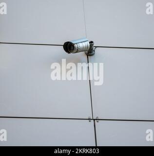 Surveillance camera on the wall of the building. Stock Photo
