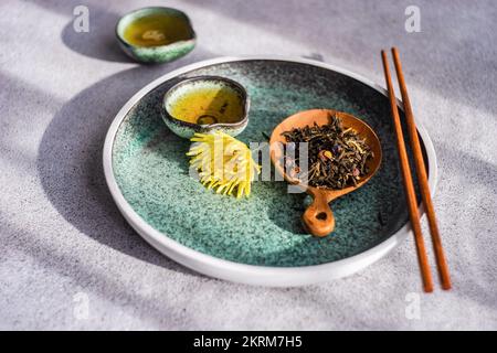 Asian green tea set with yellow autumnal Chrysanth flowers served on concrete table Stock Photo