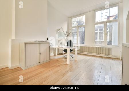 Interior of contemporary loft style office with comfortable chairs placed at tables with modern computers in daylight Stock Photo