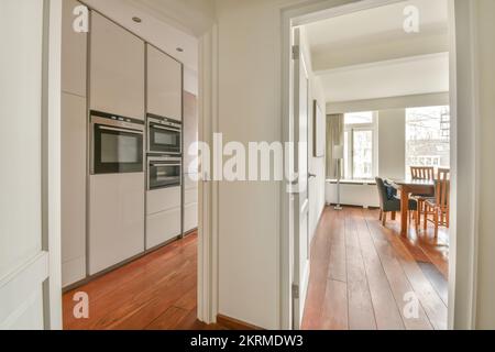 White kitchen with white cabinets near dining room at home Stock Photo