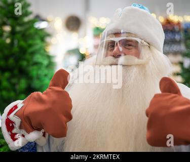 Portrait of Russian santa claus wearing a protective visor shows thumbs up. Stock Photo