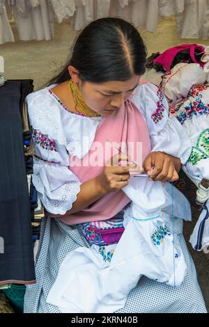 Young woman crocheting, Otavalo market, Imbabura Province, Ecuador Stock Photo