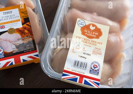 Packets of Tesco branded chicken on a kitchen worktop with a British flag marking on the packet and the Red Tractor Certified Standards label. UK Stock Photo