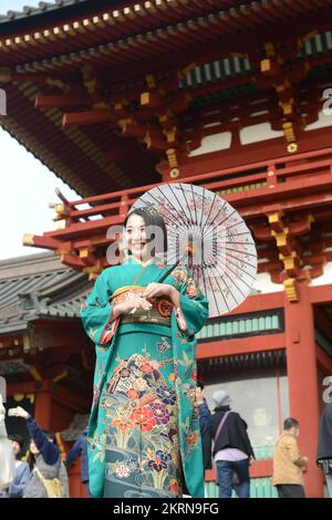 A young Japanese woman wearing a traditional Kimono and holding an Oil-paper umbrella at the Tsurugaoka Hachimangū Shinto shrine in Kamakura, Japan. Stock Photo