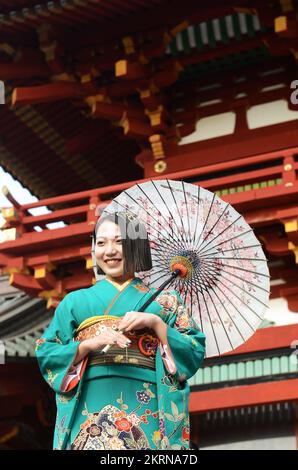 A young Japanese woman wearing a traditional Kimono and holding an Oil-paper umbrella at the Tsurugaoka Hachimangū Shinto shrine in Kamakura, Japan. Stock Photo