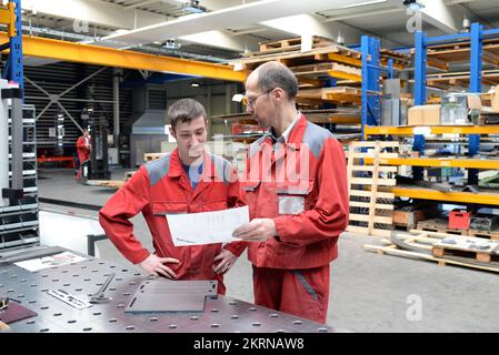 Vocational training in metal construction - apprentice and skilled worker talking and learning - careers for young people in the industry Stock Photo