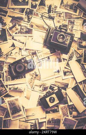 3 vintage analogue cameras on a visual archive of bygone photos. Visual stories from past times Stock Photo