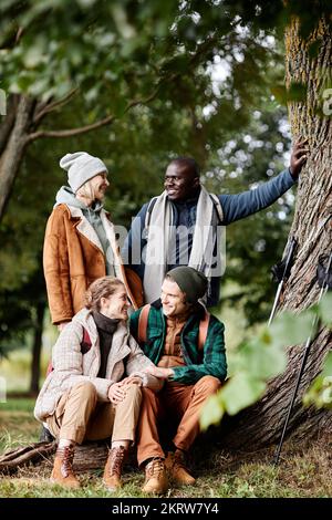 Diverse group of four friends enjoying hike in forest Stock Photo