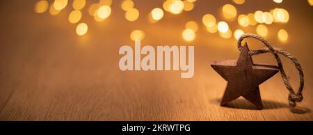Decorative wooden Christmas star on the background of bokeh lights Stock Photo
