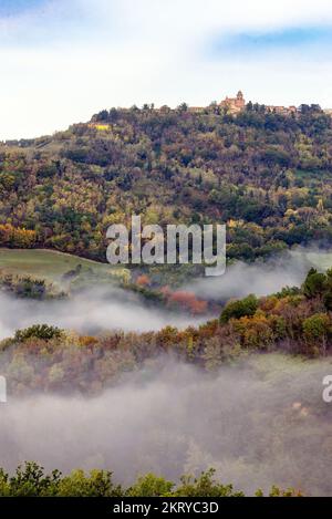 Morning mist under Mondaino, Emilia Romagna region, seen from Belvedere Fogliense between Pesaro and Urbino in the Marche region of Italy Stock Photo