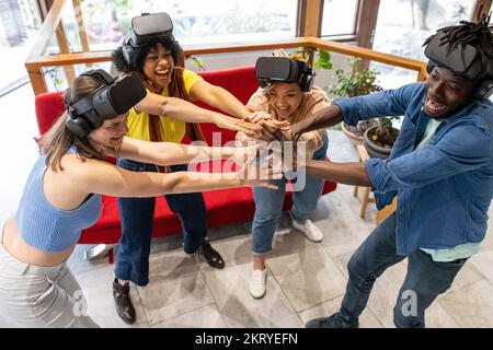 Group of friends of age and mixed ethnicity are preparing to play, time for harmony and mutual support before the virtual game, winning team hands up Stock Photo