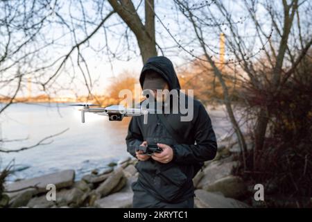 A young man launches a mini drone into the air Stock Photo