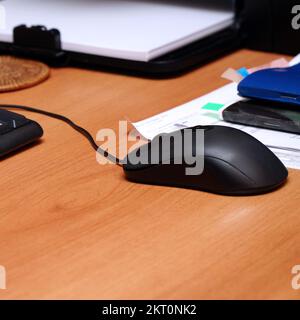 Black computer mouse on the desktop in the office Stock Photo