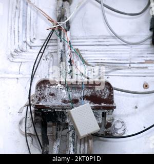 An old dirty telephone or electrical junction box on the wall. Selective focus Stock Photo