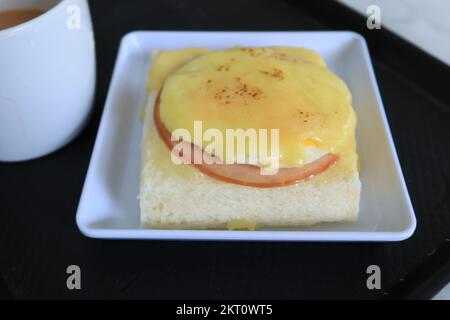 cured ham, egg and bread and cup of tea on table  Stock Photo