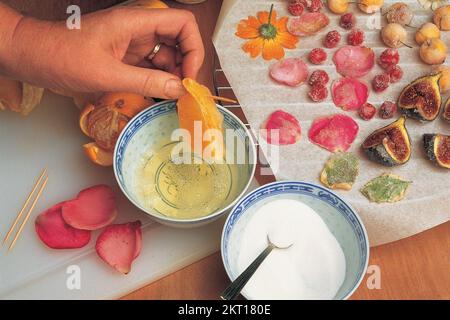 Dipping an orange segment into egg yolk Stock Photo